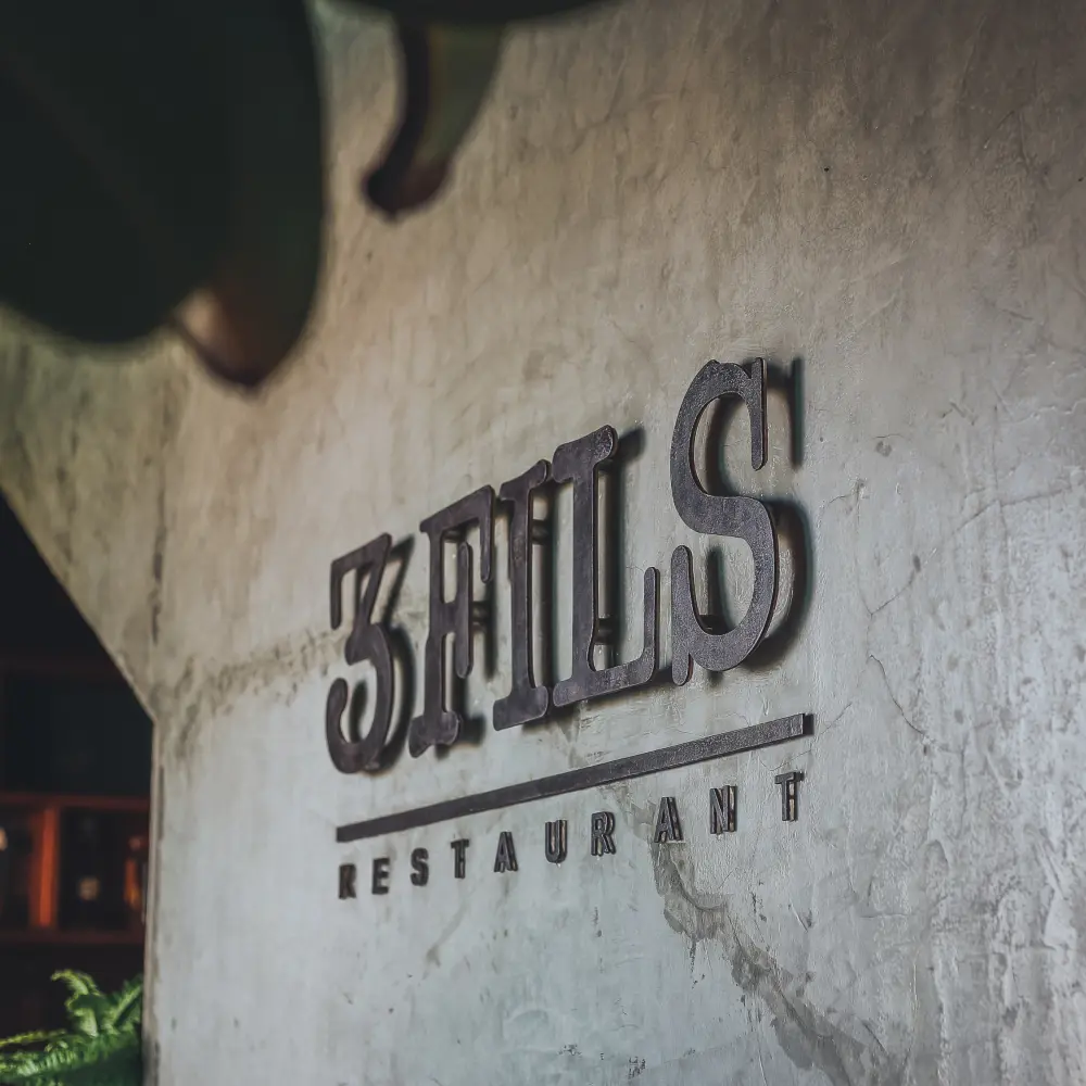 3Fils Restaurant sign on textured wall