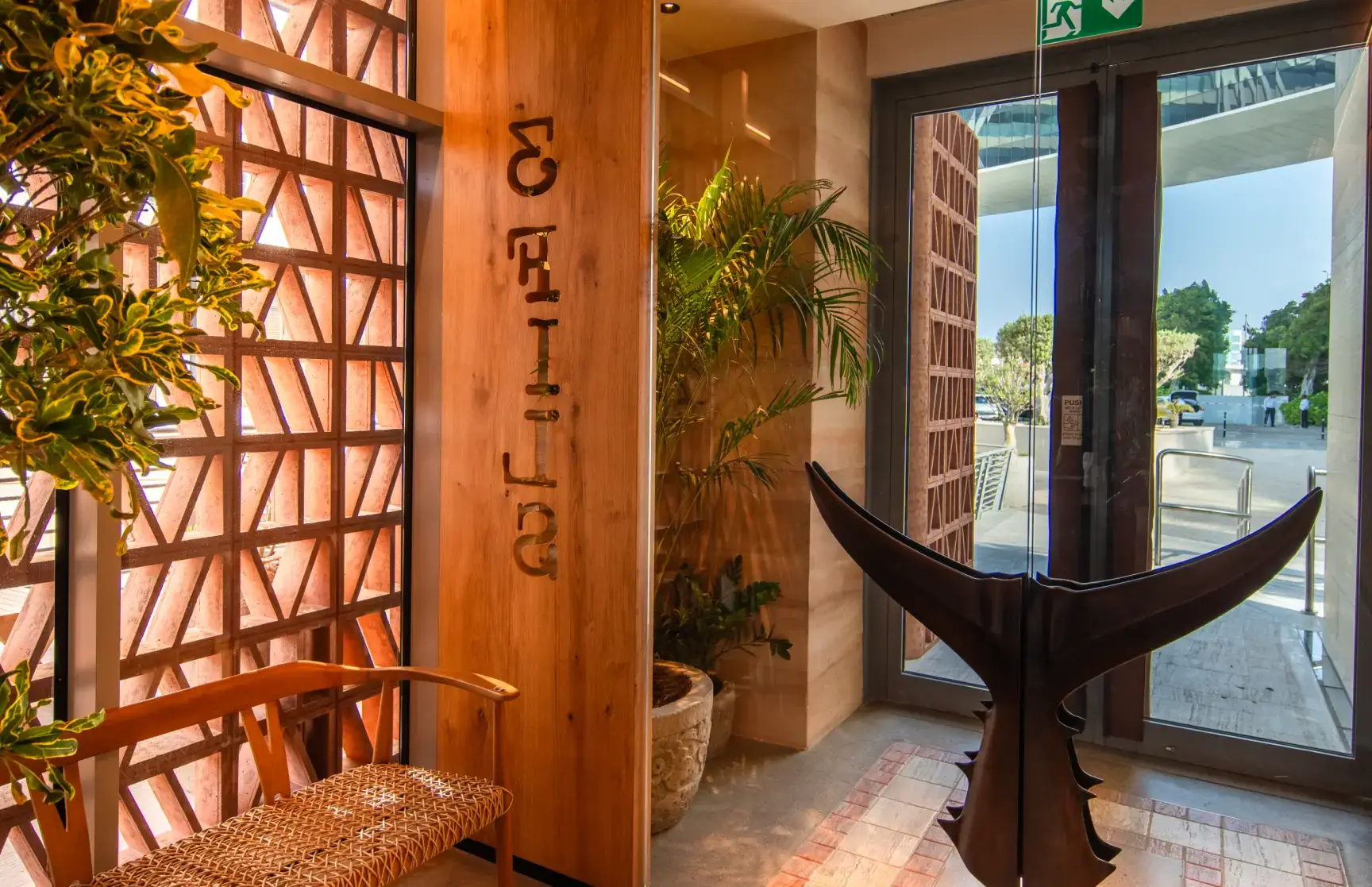 3Fils entrance with wooden signage and whale tail sculpture