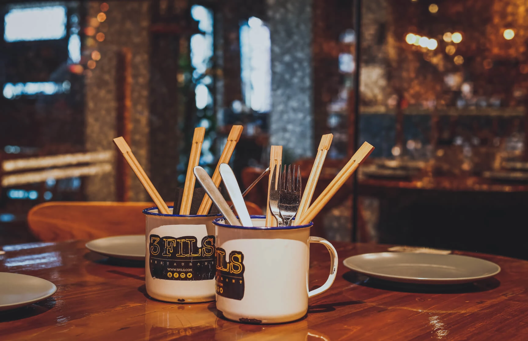 3Fils branded mugs with chopsticks and cutlery on the table