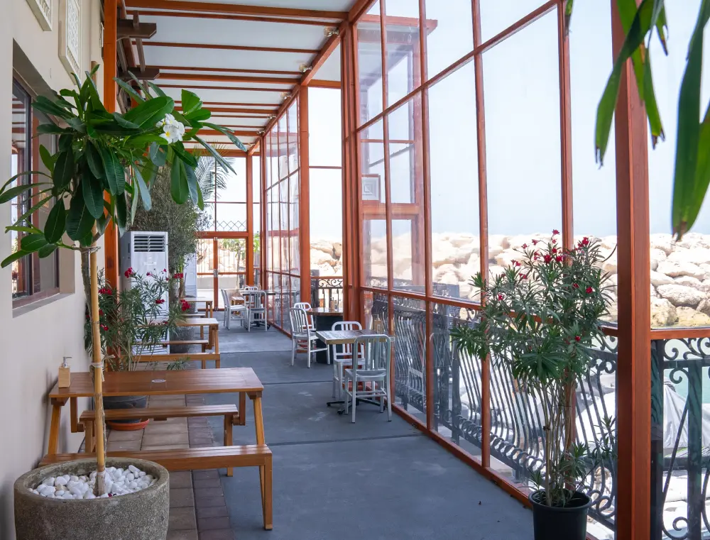 3Fils harbour-side covered terrace with wooden tables and plants